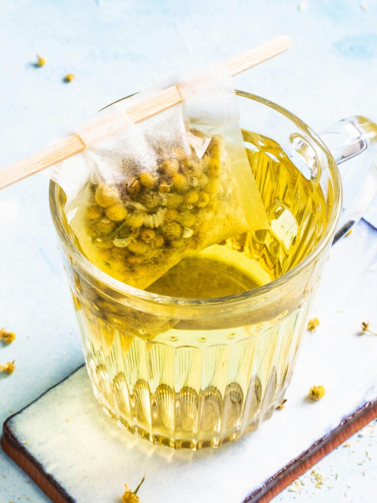 chamomile tea in a glass mug with a coaster underneath