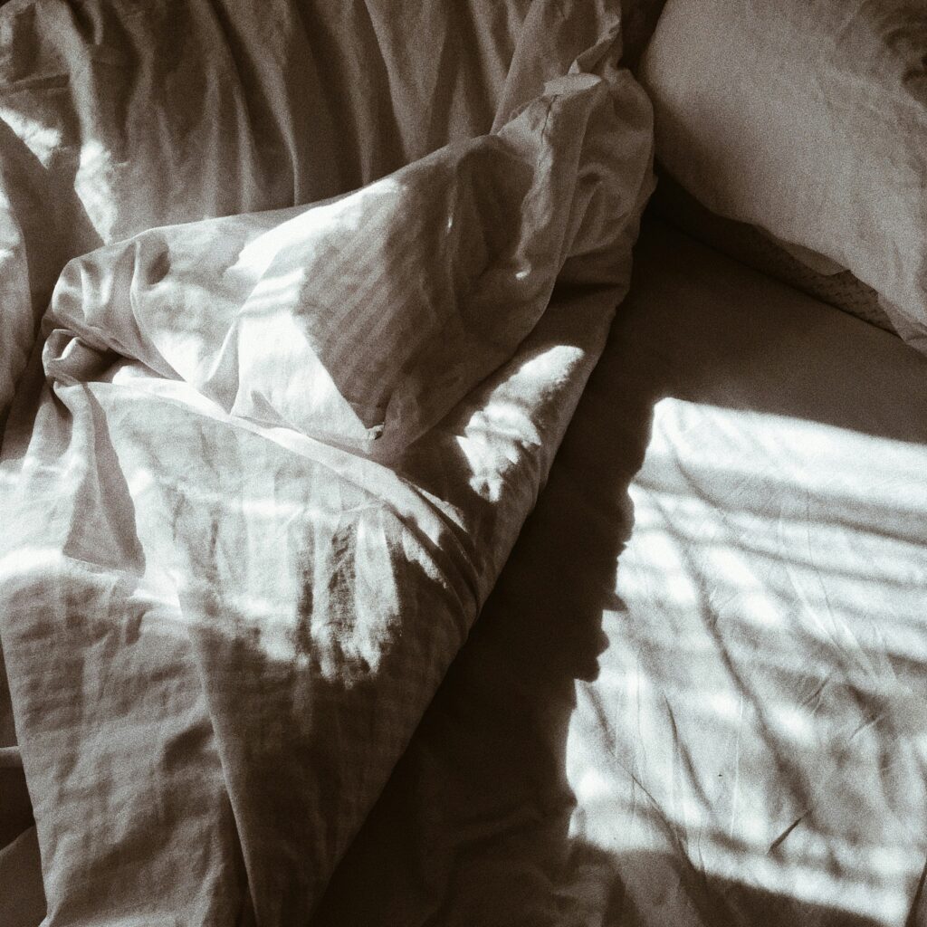 bed with folded duvet and pillow