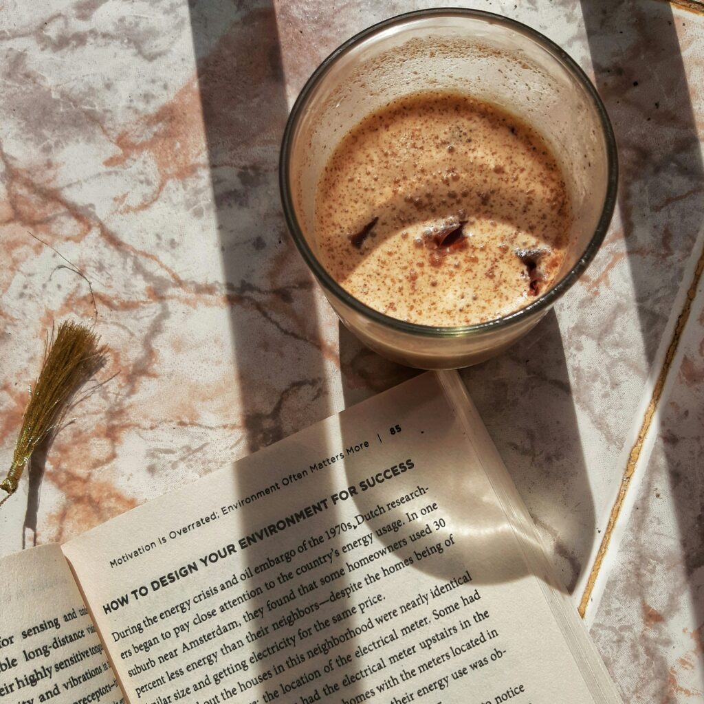mug with a drink inside next to a book